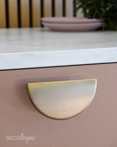 Detailfoto van een la in een kast. De kast is gemaakt van decoratief plaatmateriaal van Cleaf. met de look van geborsteld aluminium. Op de la zit een mooie greep in de vorm van een halve maan van Prodinter