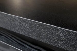 Detailafbeelding van een werkblad, uitgevoerd in het deocratief plaatmateriaal U129 Primofiore van Cleaf, welke een matzwarte uitstraling van leer heeft.