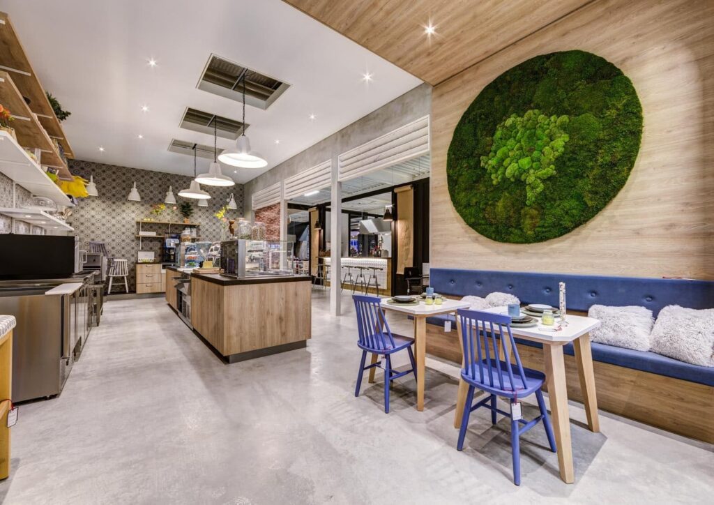 Wandafwerking en een vrijstaande counter in het restaurant van een showroom gemaakt van decoratief plaatmateriaal met eikenhout look, de S128 Pembroke van Cleaf.