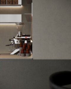 Detailafbeelding van een bar uitgewerkt in het donkergrijze plaatmateriaal FD16 Taranta van Cleaf in combinatie met een blad uitgewerkt in het gekorrelde solid surface decor TS053 Old Castle van Durasein. De wandafwerking uitgewerkt in het lichtgrijze decor FD16 Taranta van Cleaf