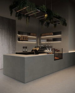 Zijaanzicht van een horecagelegenheid met een bar uitgewerkt in het donkergrijze plaatmateriaal FD16 Taranta van Cleaf in combinatie met een blad uitgewerkt in het gekorrelde solid surface decor TS053 Old Castle van Durasein. De wandafwerking uitgewerkt in het lichtgrijze decor FD16 Taranta van Cleaf met een deur in de S212 Corteccia, welke de beleving van gerookt grijs kastanjehout biedt.