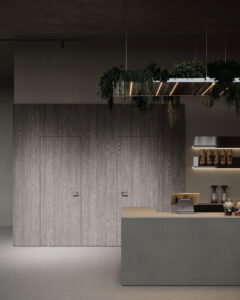 Een render van een horecagelegenheid met een bar uitgewerkt in het donkergrijze plaatmateriaal FD16 Taranta van Cleaf in combinatie met een blad uitgewerkt in het gekorrelde solid surface decor TS053 Old Castle van Durasein. De wandafwerking uitgewerkt in het lichtgrijze decor FD16 Taranta van Cleaf met een deur in de S212 Corteccia, welke de beleving van gerookt grijs kastanjehout biedt.