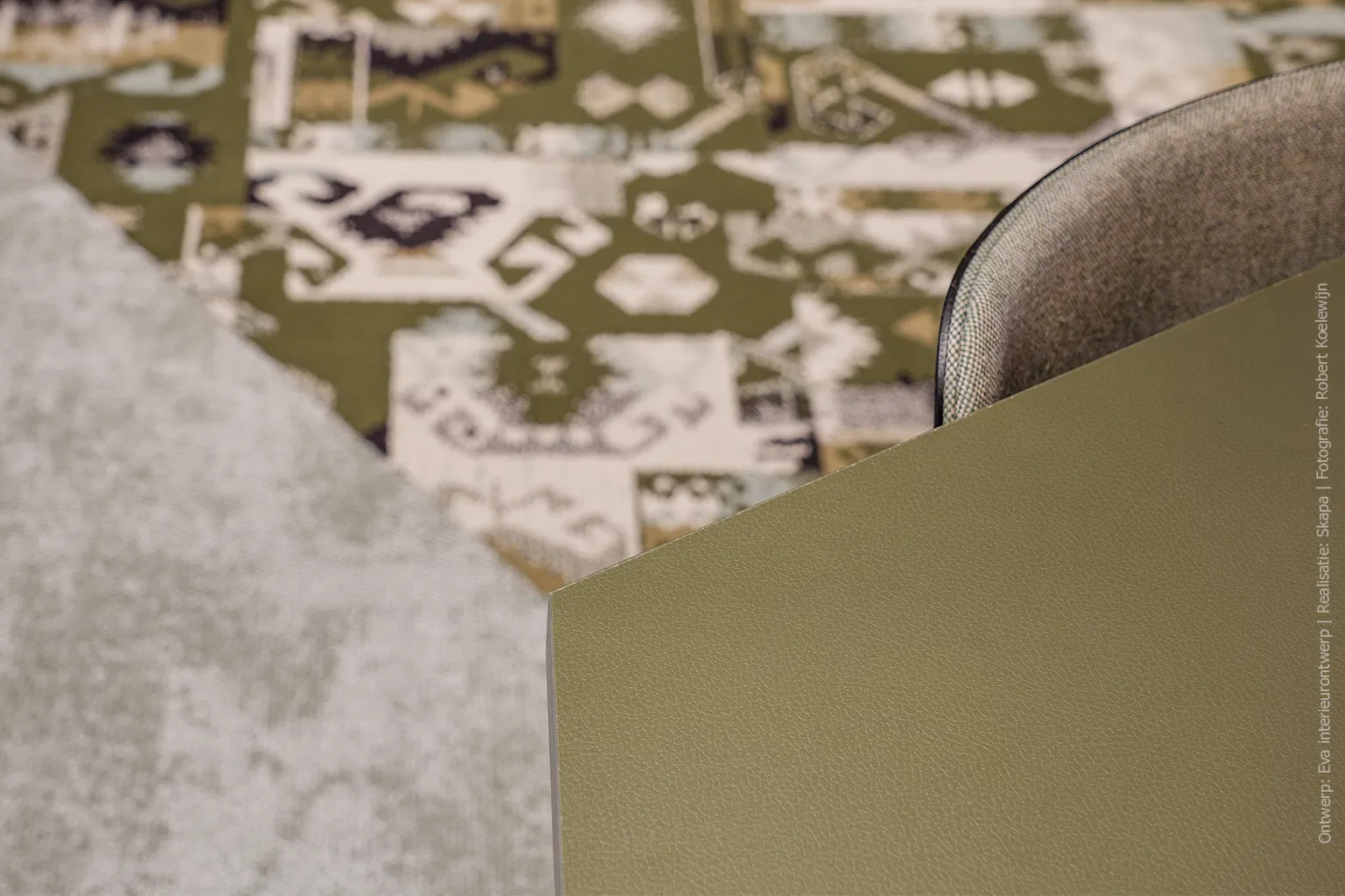Detailfoto van vergadertafel afgewerkt in UB54 Primofiore met een leerachtige structuur in legergroene tint