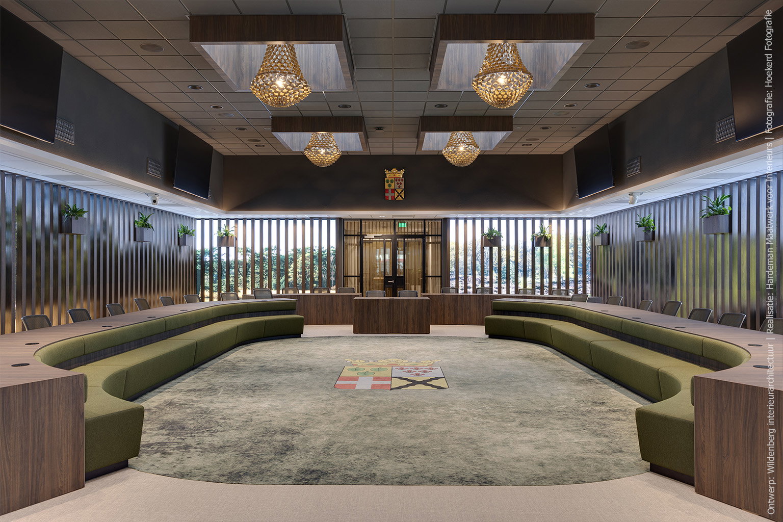 Raadszaal met grote vergadertafel in Cleaf LS17 Poro Noce, groene zitbanken en verticale raamdecoratie.