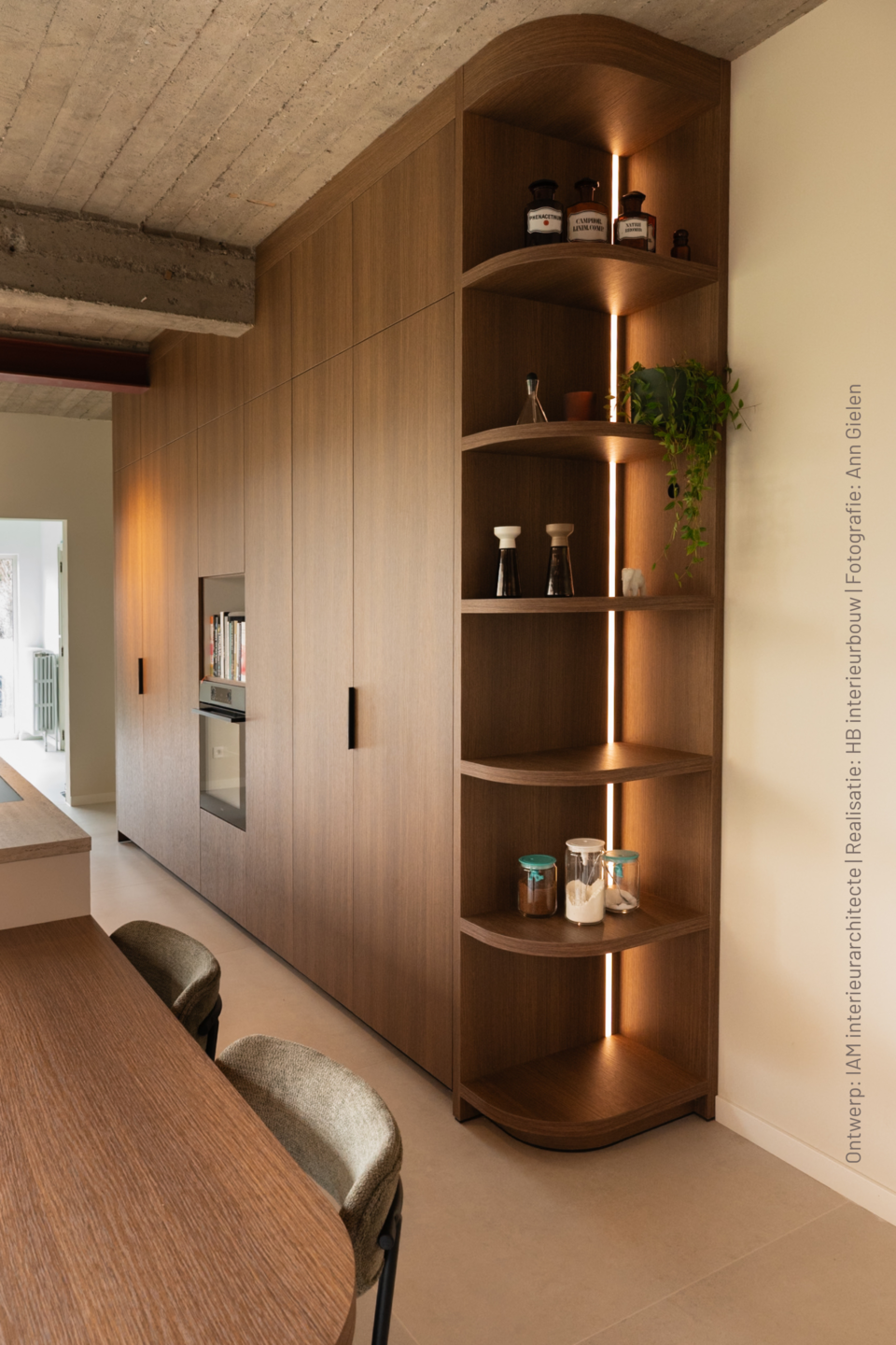 Maatwerkkastenwand en open hoekrek in S185 Quercia, een warm houtdecor met natuurlijke nerf, gecombineerd met geïntegreerde oven en sfeervolle verlichting.