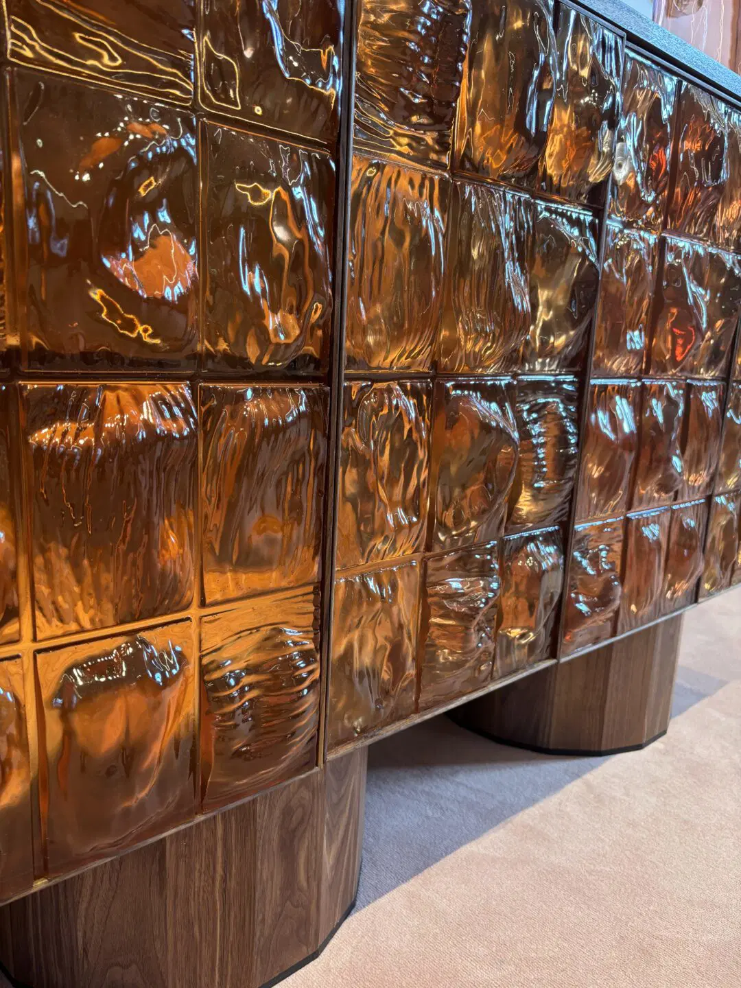 Inspiratieafbeelding van Milaan Design Week van een dressoir van oranje glas met houten poten. 
