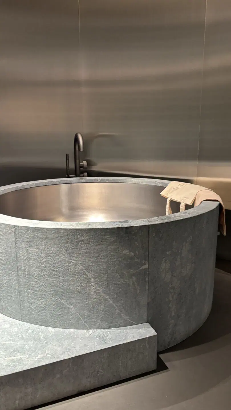 Inspiratieafbeelding van Milaan Design Week waar een bad van beton en RVS wordt getoond. 