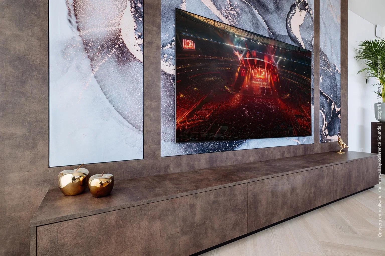 Cinewall in decor FA33 Primofiore met groot tv-scherm, flankerende decoratieve panelen en gouden accessoires op het lage meubel.