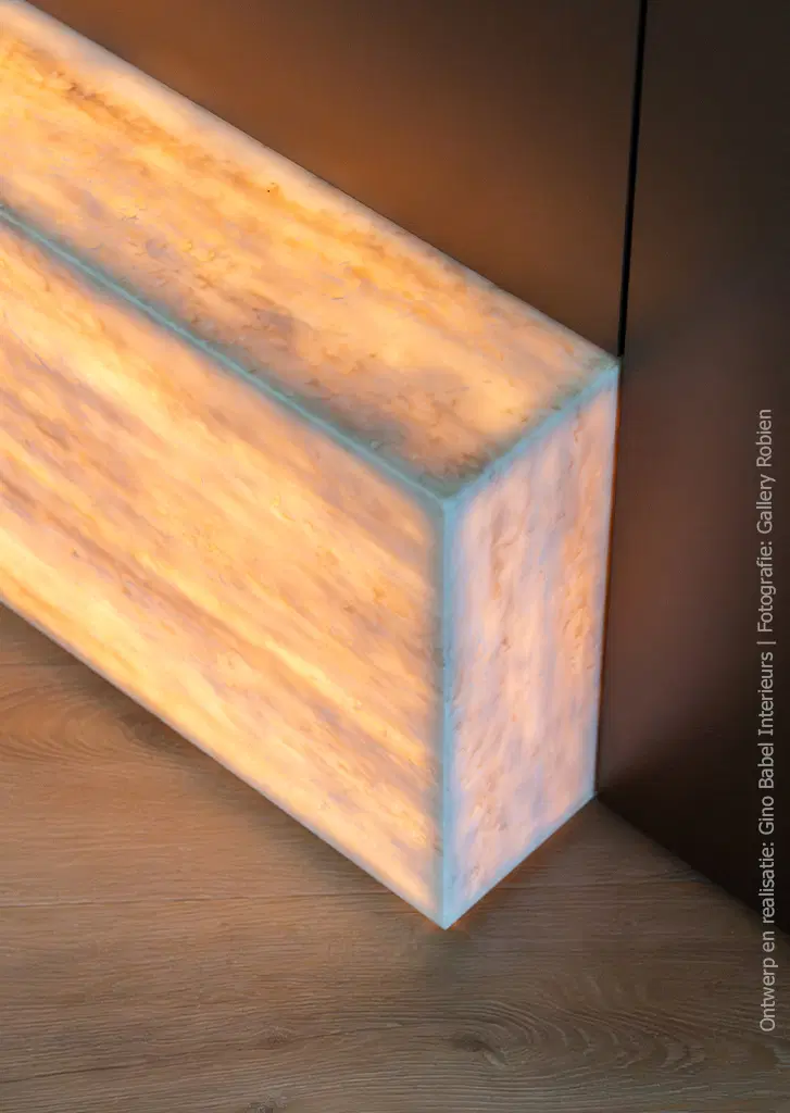 Detail van maatwerkkast met solid surface in DM5002 Weathered Wood, waarbij het licht diffuus door het materiaal schijnt, gecombineerd met fronten in FA84 Reflex met een subtiele verticale glansdraad