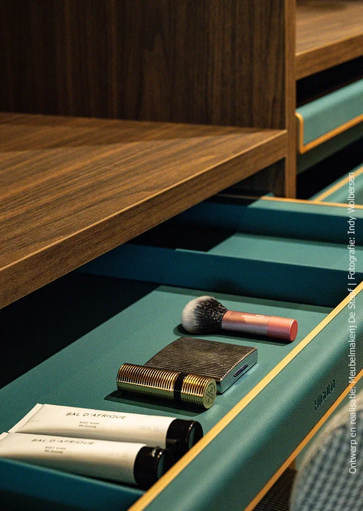 Detailopname van open HIGOLD lade in groenblauw met gouden rand, in LS17 Poro Noce maatwerk inloopkast van Meubelmakerij De Stoof.