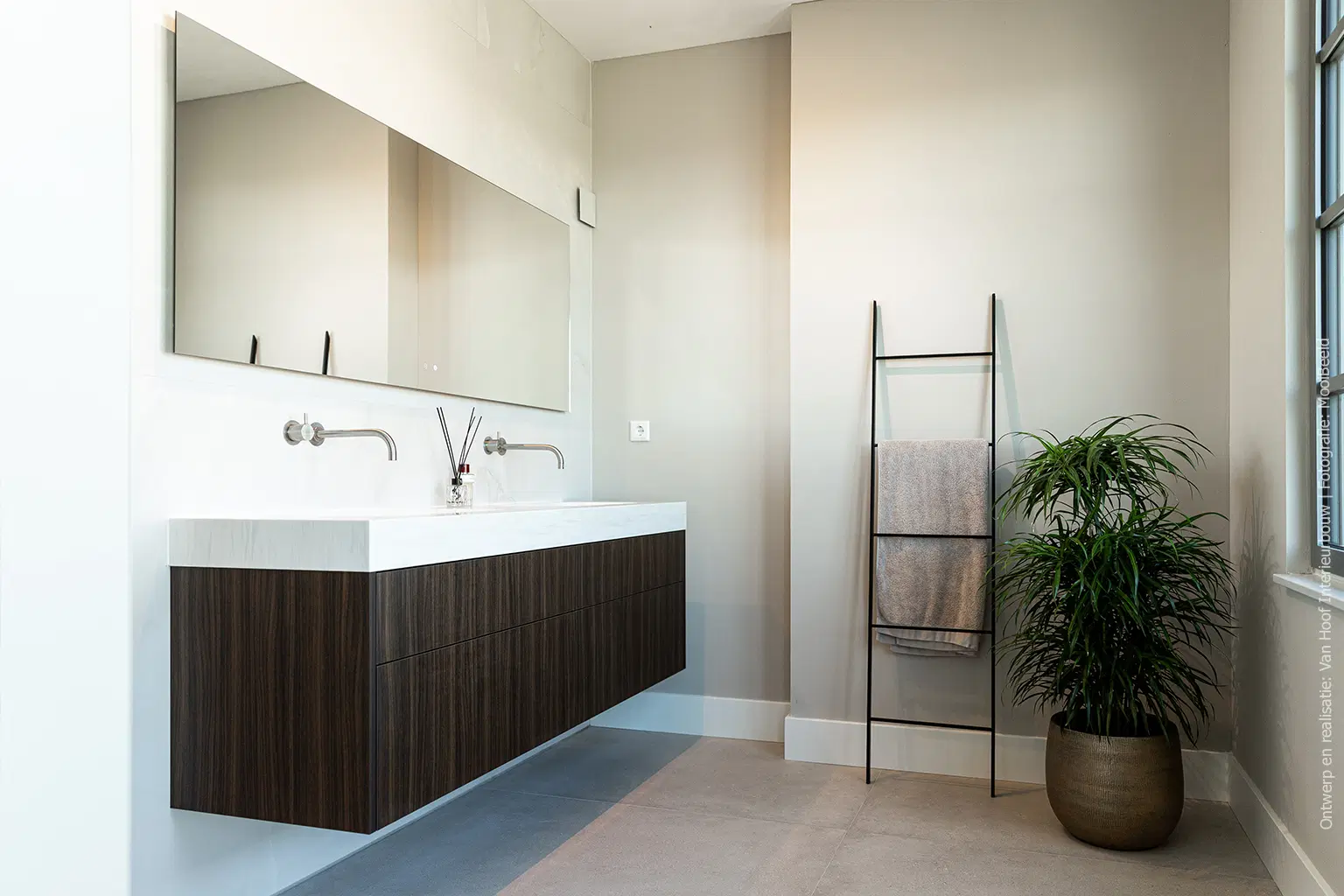 Donker walnoot en roomwit solid surface komen samen in de badkamer