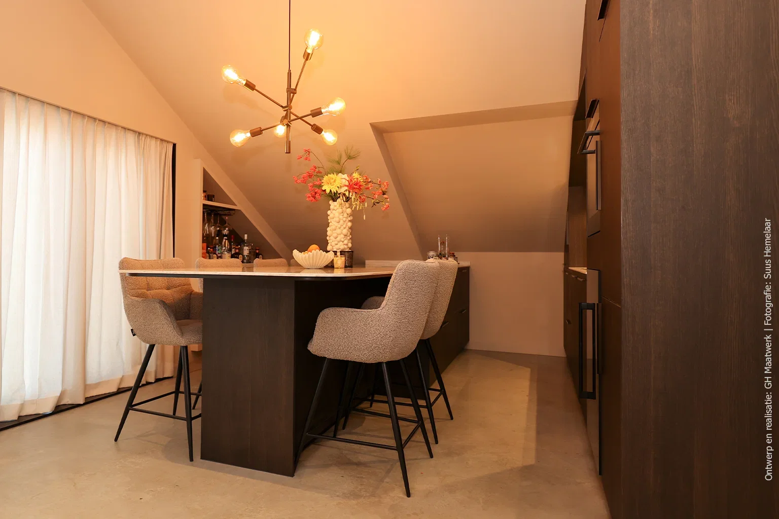 ookeiland in decor S003 Spessart met DM5002 Weathered Wood werkblad en geïntegreerd zitgedeelte, met verlichte bar op de achtergrond.