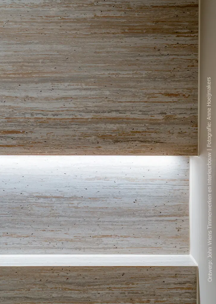 Detailfoto van inloopdouche in solid surface decor DM5016 Travertine, met warme beige- en bruintinten en een levendige natuursteenstoructuur