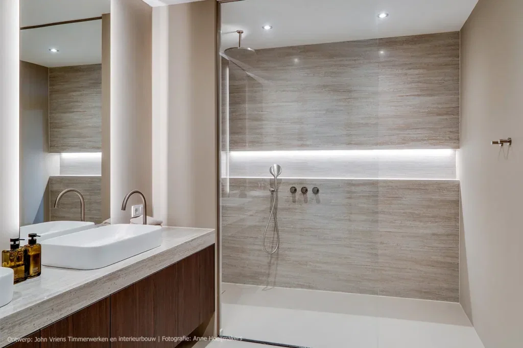 Een verfijnde balans tussen donker hout en travertine in de badkamer