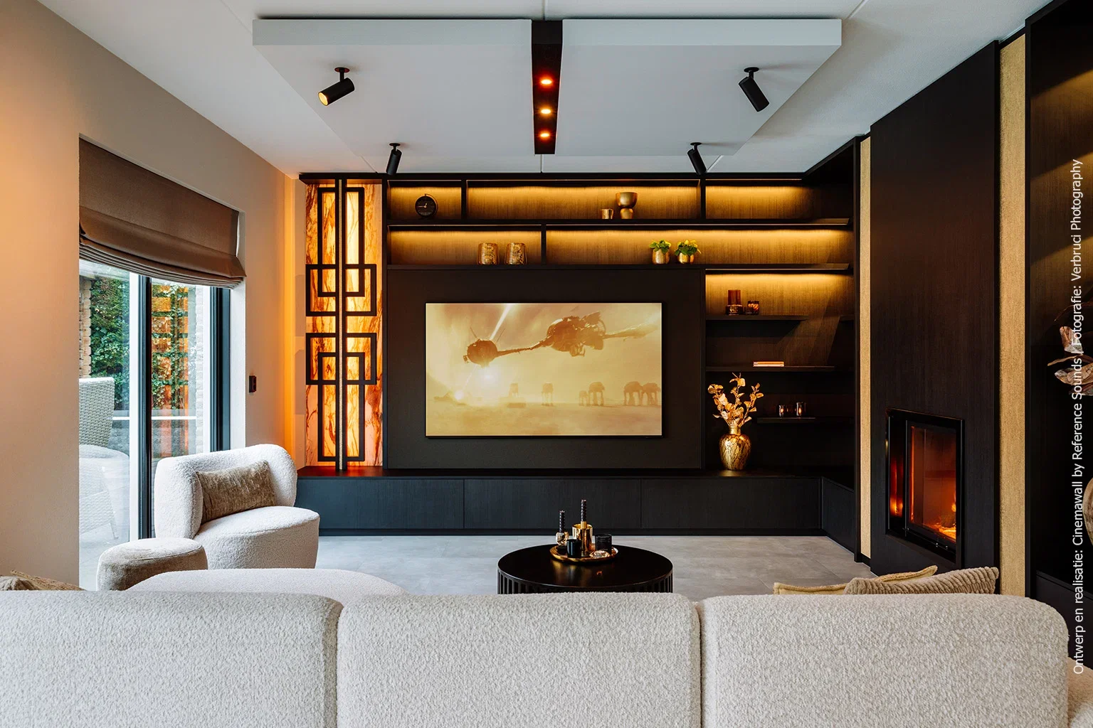 Totaaloverzicht van een woonkamer met cinewall in U129 Esperia, geïntegreerde haard en projectie op groot scherm.
