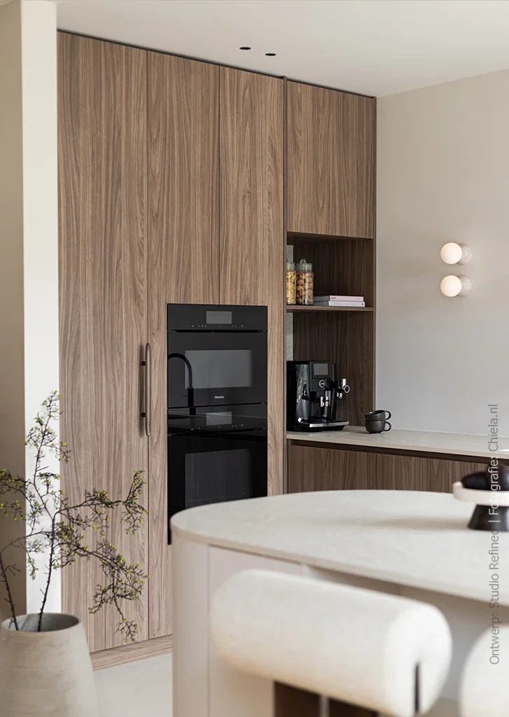 Warm lichtbruin walnootdecor LS13 Poro Noce toegepast op de hoge en lage kasten van een moderne keuken met een licht kookeiland