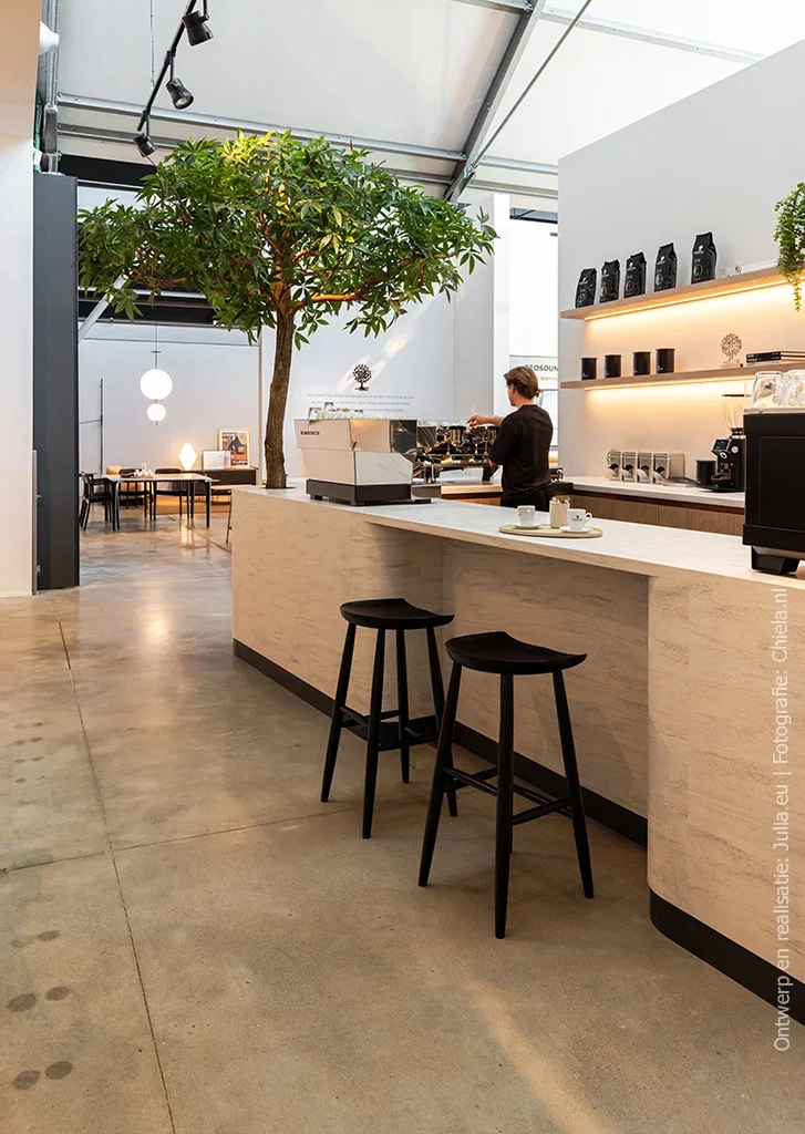 Koffiebar in een koffie-experiencecenter, uitgevoerd in solid surface decor DM5001 Niagara met vloeiende aders in beige, lichtgrijs en fris wit.