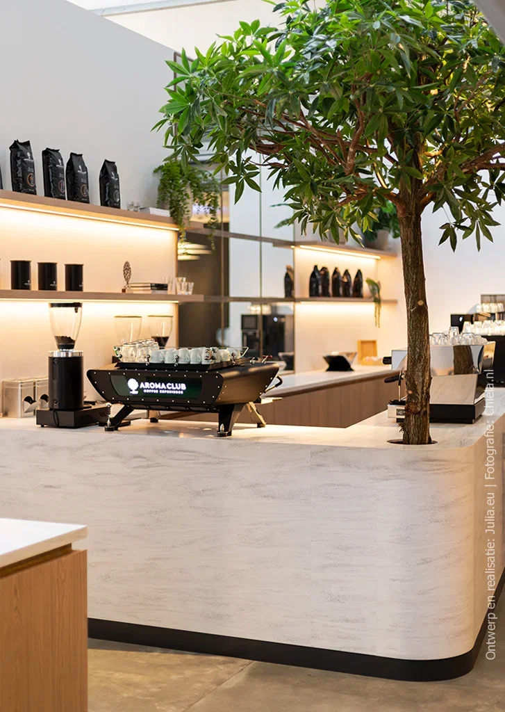 Koffiebar in een koffie-experiencecenter, uitgevoerd in solid surface decor DM5001 Niagara met vloeiende aders in beige, lichtgrijs en fris wit.